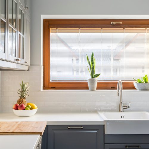 Light kitchen with white countertop, sink, window and grey furniture