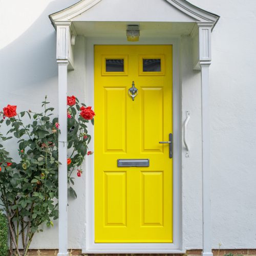 Beautiful yellow front door of English flat house